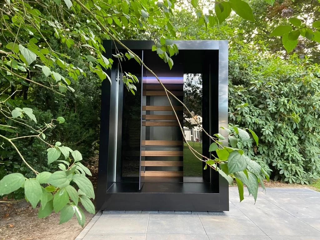 Luxe kubusvormige design compacte buitensauna met infrarood, glazen voorwand en moderne aluminium afwerking, in de tuin voor een ultieme outdoor wellness ervaring.