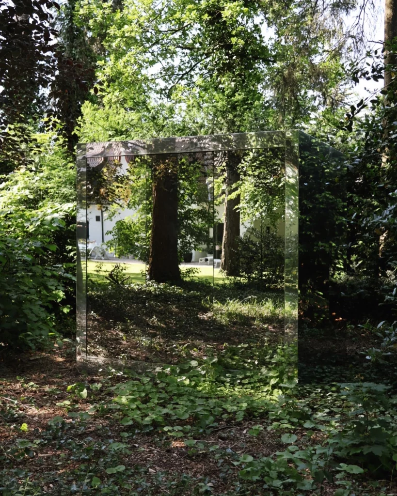 Luxe kubusvormige design buitensauna met moderne spiegelglasafwerking, in de tuin voor een ultieme outdoor wellness ervaring.