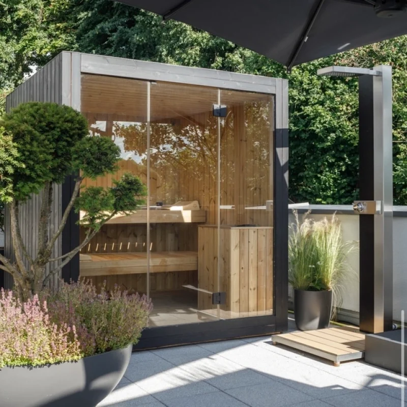 Luxuriöse kubusförmige Design-Außensauna mit Glasfront und moderner Thermoholz-Oberfläche, im Garten für ein ultimatives Outdoor-Wellness-Erlebnis.