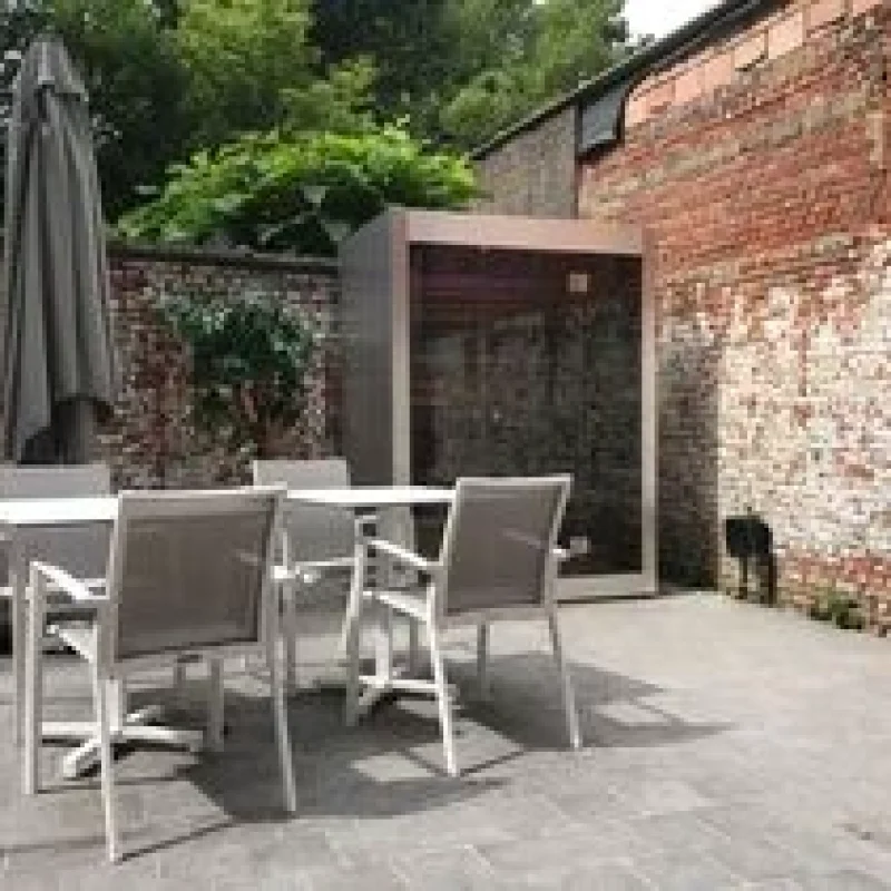 Luxe kubusvormige design compacte buitensauna met glazen voorwand en moderne inox afwerking, in de tuin voor een ultieme outdoor wellness ervaring.