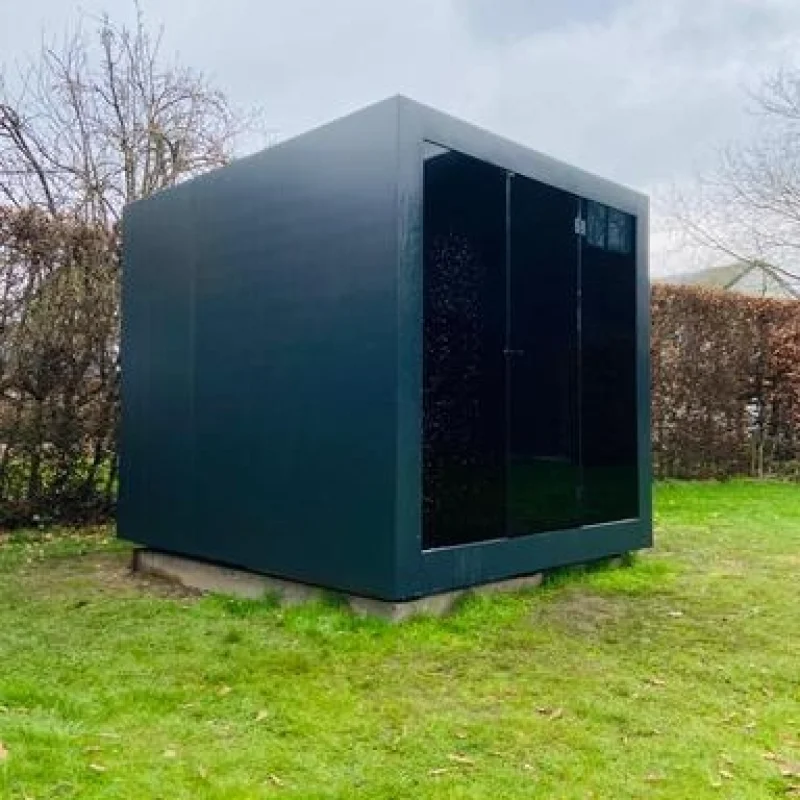 Luxury cube-shaped design outdoor sauna with glass front and modern aluminium finish, in the garden for the ultimate outdoor wellness experience