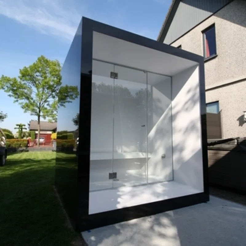 Luxury cube-shaped design outdoor steam cabin with glass front and modern aluminium finish, in the garden for the ultimate outdoor wellness experience.